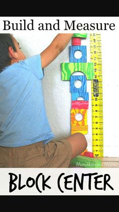 a young boy sitting on the floor next to a giant ruler with words build and measure