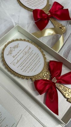 two white boxes with red bows and gold trims on them, one containing a wedding program