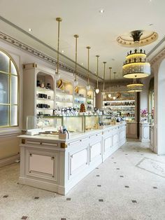 the inside of a store with many bottles on shelves and chandeliers hanging from the ceiling