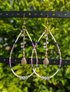 -Handmade native beaded drop hoop earrings with gold fishhook earring backs -Shades of blue, purple and pink seed beads with gold accents -4 inches long, 1 3/4 inches wide -All pieces of jewelry are made with TLC by myself, Demiree! Purple Beaded Hoop Earrings With Round Beads, Purple Beaded Dangle Hoop Earrings, Handmade Purple Dangle Hoop Earrings, Bohemian Purple Hoop Earrings, Artisan Beaded Purple Earrings, Drop Hoop Earrings, Fish Hook Earrings, Beaded Hoop Earrings, Beaded Hoops