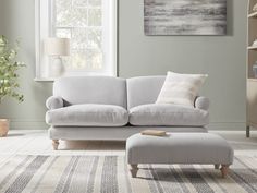 a living room scene with focus on the couch and ottoman