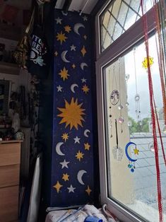 there is a window with stars and moon designs on the wall in front of it