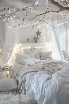 a bed with white sheets and lights on the ceiling, in a bedroom decorated for christmas