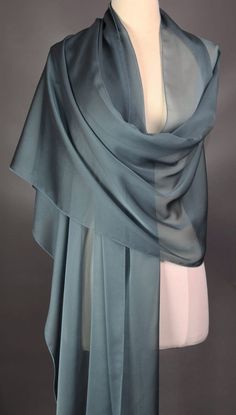 This scarf is iridescent elegance and is definitely a muted blue. Monitor may reflect the scarf brighter than what it actually is.  Perfect for all seasons.  Dress it up or dress it down.  The choice is yours.  All of my scarves can be dressed up or down. I finish my scarves with a machine rolled hem.  I am constantly looking for unusual fabrics that would make wonderful scarves. Be nice to your scarves and they will last a long, long time. Enjoy the scarf and wear it with confidence.  Polyester Elegant Blue Shawl Scarves, Elegant Blue Scarves For Party, Elegant Blue Scarves For Wedding, Elegant Blue Scarf For Wedding, Elegant Blue Silk Shawl Scarf, Elegant Blue Silk Scarf For Evening, Elegant Blue Silk Scarf For Formal Occasions, Elegant Blue Silk Scarf For Wedding, Elegant Silk Scarf For Party