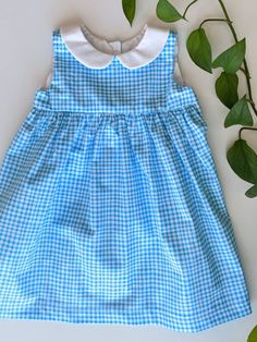 This 12-18 month blue and white gingham sleeveless dress is perfect for the summer season! It's finished off with a simple white collar and back button closures. This geranium dress pattern is used with permission and designed by Rae Hoekstra of made-by-rae.com. 12-18 Month Chest (in) - 19.5 Weight (lbs) - 22-27 Height (in) - 29-31 This dress pattern is available in many variations (size, fabric pattern, sleeves, no collar, etc.) just send me a message! Gingham Dresses For School In Spring, Preppy Sleeveless Summer Dress, Sleeveless Plaid School Dress, Plaid Sleeveless School Dress, Preppy Sleeveless Dress For Picnic, Preppy Plaid Sleeveless Dress, Cute Sleeveless Cotton Plaid Dress, Cute Sleeveless Spring Plaid Dress, Plaid Summer Dress For School