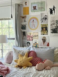 there is a bed with many pictures on the wall and stuffed animals sitting on it