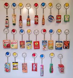 a bunch of food items are hanging on the wall with some key chains attached to them