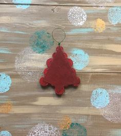 a red ornament hanging from a string on top of a wooden table with blue and gold circles