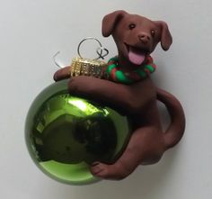 a brown dog sitting on top of a green ornament