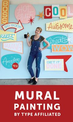 a woman standing in front of a wall with signs on it and the words mural painting by type affixed