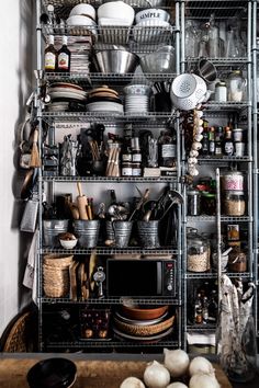 the shelves are filled with many different types of dishes and cooking utensils on them