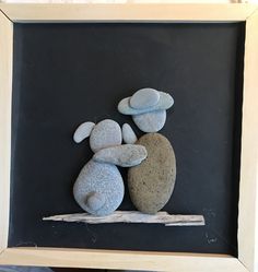 two rocks sitting on top of each other in a frame