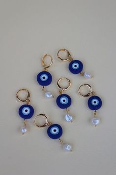 six pairs of blue evil eye earrings with pearl beads and gold plated ear wires