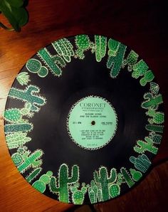 a record sitting on top of a wooden table next to a potted green plant