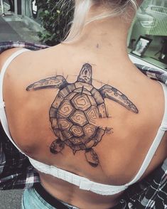 a woman with a turtle tattoo on her back