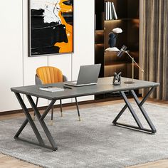 a desk with a laptop on it in front of a book shelf and a painting