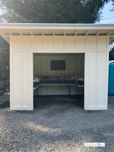 a small white building with a table in it