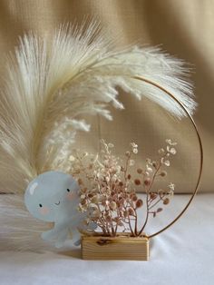 an elephant figurine sitting on top of a table next to a vase filled with flowers