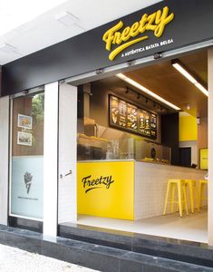 the front of a fast food restaurant with yellow stools