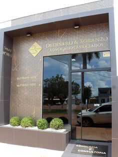 a car is parked in front of the entrance to a building with glass doors and windows