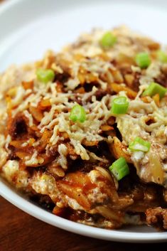 a close up of a plate of food with meat and cheese on it, sitting on a table