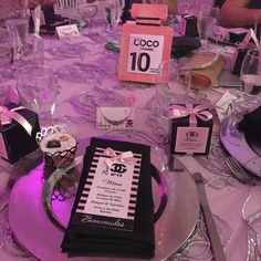 the table is set up for an event with purple lighting and place cards on it