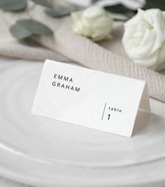 a place card is placed on a plate with flowers and napkins in the background