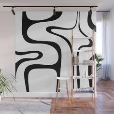 an abstract black and white wall mural in a living room with a ladder to the right