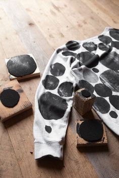 some black and white polka dots are on the floor next to pieces of wood that have been carved into them