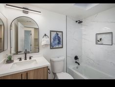 a bathroom with marble counter tops and white walls