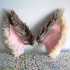 two feathers are attached to the back of a stuffed animal's head on a map