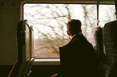 a man sitting on a train looking out the window