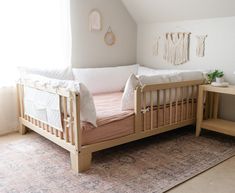 a white crib in the corner of a room with a rug on the floor