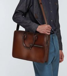 This Berluti briefcase is made in Italy from brown leather. It features two top handles, a detachable shoulder strap, and a subtle embossed logo..Closure: two-way zipped top.Color of fastening: antique silver.Internal details: fabric lining, internal slot pockets, internal zipped pocket.Material: leather.zipped front pocket.Made in Italy.detachable, adjustable shoulder strap, top handles.Height 27cm-10.5'.Width 38cm-15'.Depth 6cm-2.5'.Length of handles 35cm-14'.Min. length shoulder strap 124cm-4 Formal Satchel Laptop Bag With Top Carry Handle, Business Leather Briefcase With Detachable Handle, Business Satchel Briefcase With Detachable Handle, Leather Shoulder Bag Briefcase For Business, Formal Laptop Satchel With Top Carry Handle, Leather Shoulder Briefcase For Business, Leather Shoulder Briefcase For Work, Leather Briefcase With Detachable Handle For Business, Business Laptop Bag With Detachable Strap And Double Handle