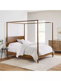 a bed with white sheets and pillows in a room next to a table, dresser and window