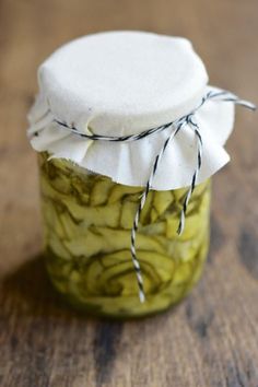 a jar filled with pickles sitting on top of a wooden table