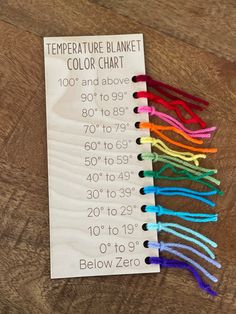 there is a paper that has some colored yarn on it with the words temperature blanket color chart