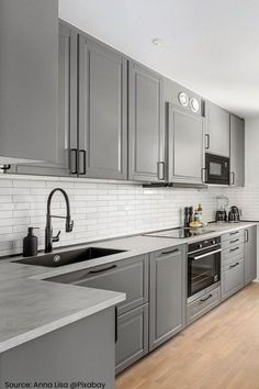 a kitchen with stainless steel appliances and wooden floors