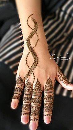 a woman's hand with henna tattoos on it