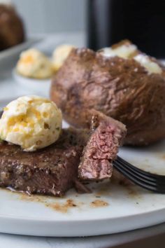 a piece of steak with mashed potatoes on a white plate next to a baked potato