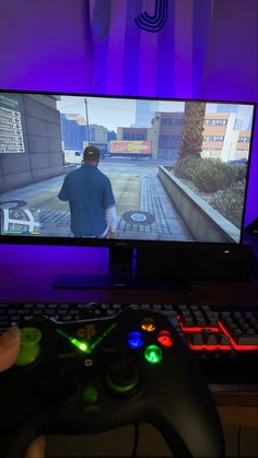 a person holding a game controller in front of a computer screen with a video game on it