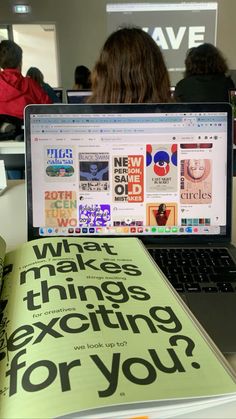 an open laptop computer sitting on top of a desk next to a book with the words what makes things exciting for you?