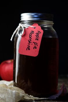 an apple cider is sitting next to some apples