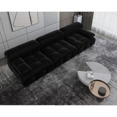 a black and white couch sitting on top of a rug next to a coffee table