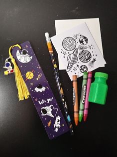 some pens and markers are sitting on a table