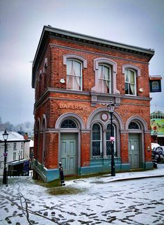 an old red brick building on a snowy day