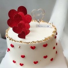 a white cake with red hearts on it