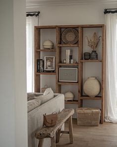 a living room filled with lots of furniture and decor on top of wooden bookshelves