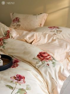 a coffee cup is sitting on the edge of an unmade bed with floral sheets