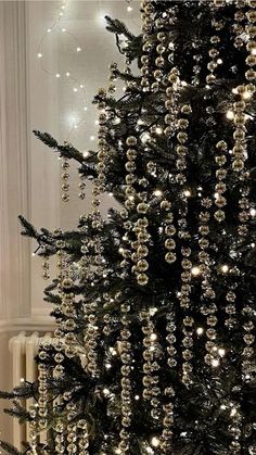 a black christmas tree decorated with gold ornaments